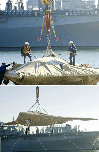 資料圖：美國(guó)海軍人員將一架X-47B無(wú)人空戰(zhàn)系統(tǒng)驗(yàn)證機(jī)運(yùn)送到杜魯門(mén)號(hào)航母上。