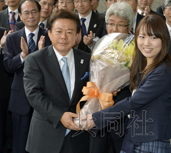 12月18日，高票當(dāng)選東京都新知事的豬瀨直樹正式到任。圖為豬瀨從政府職員手中接過花束。(共同社)