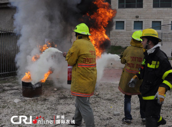 兩名志愿者在消防員的指揮下滅火。（攝影：張瑾） 
