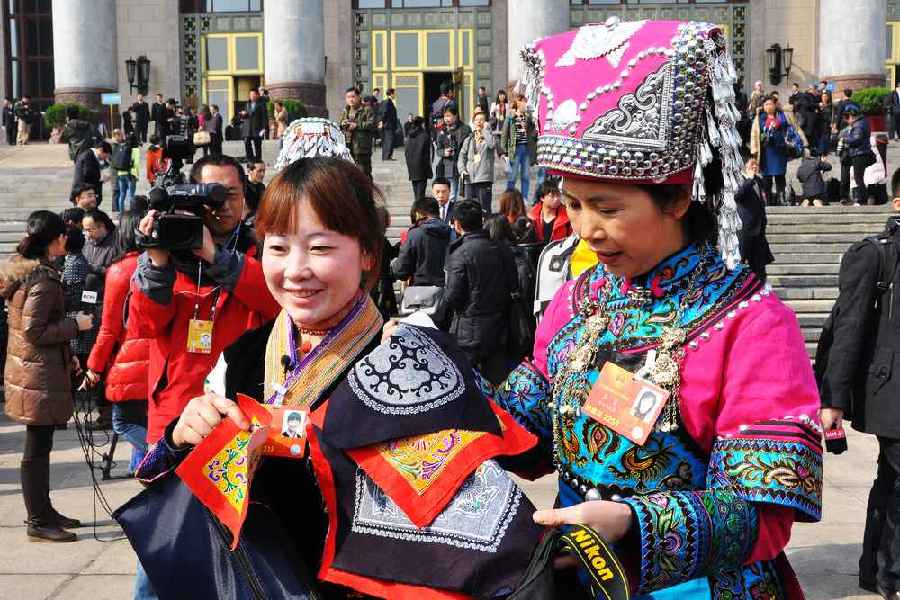 云南代表團(tuán)的兩位女代表在為記者展示她們帶來的民族特色手工藝品。 人民網(wǎng)記者 馬麗婭 攝