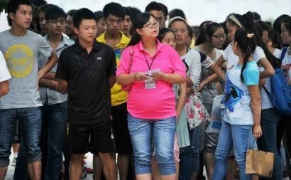6月7日，雅安天全中學(xué)的呂莎莎老師(中)在考場外等待自己的學(xué)生出來。