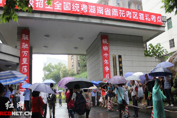 高考學子冒雨進入考場。