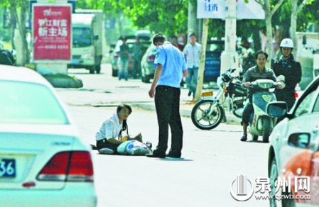 女孩從摩的上摔下，跌坐路中央，恰遇社區(qū)聯(lián)防巡邏人員扶起。