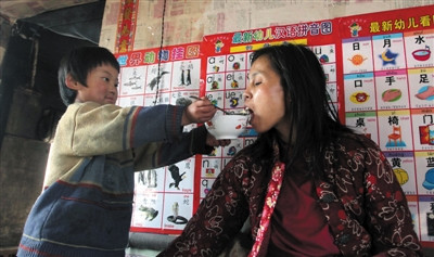 小孫悅為臥床的母親喂飯。