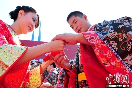 9月1日，一場(chǎng)別開生面的“重溫漢唐風(fēng)”漢式集體婚禮在泉城濟(jì)南舉行，72名新人身著傳統(tǒng)漢服喜結(jié)良緣，并在許愿墻上許下“千年共枕眠，一世永相愛”心愿。圖為新人解纓結(jié)發(fā)。中新社發(fā) 張勇 攝