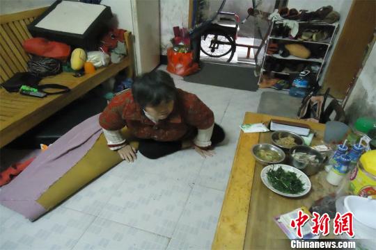 17日下午，56歲小兒麻痹癥患者張紅英爬在地板上找東西。 蘇路程 攝