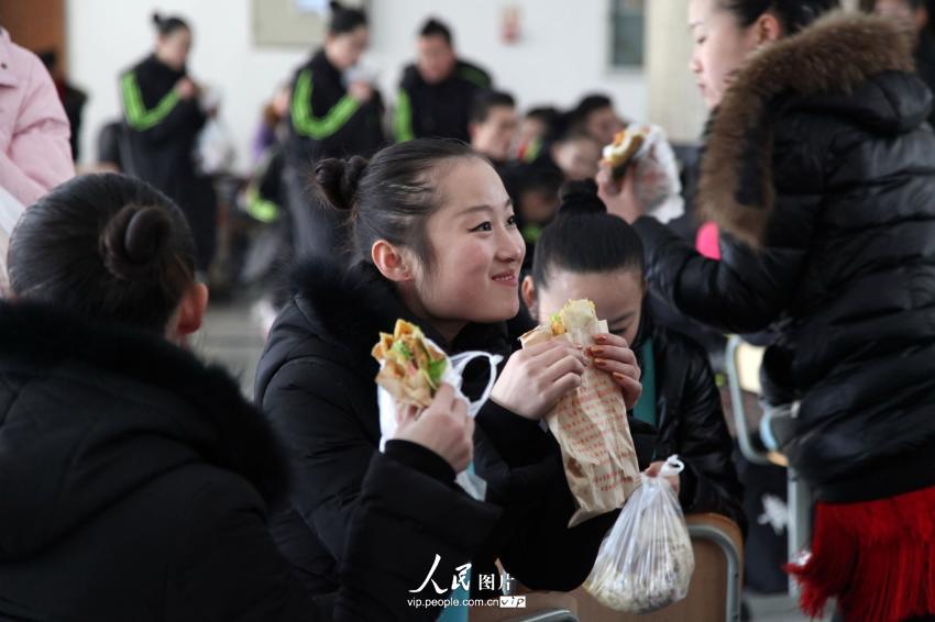 2014年2月17日，山東濱州，背著大包小包的藝考考生在濱州學(xué)院報名點候考。