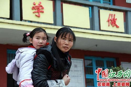 蘭愛紅背著女兒放學(xué)。