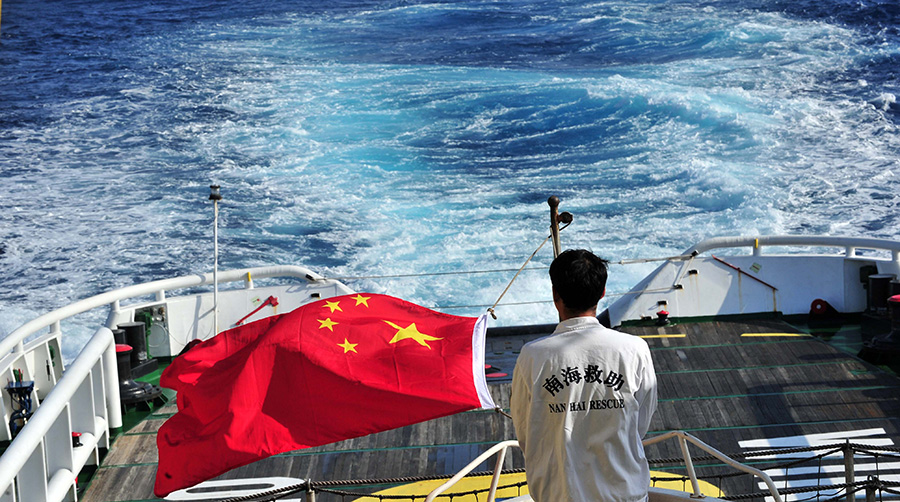 3月18日，水手李國(guó)棟在南海救101輪船甲板后部升起國(guó)旗。新華社記者 趙穎全攝