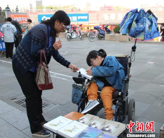 洛洛正在給買書的顧客簽名。 馮曉林 攝