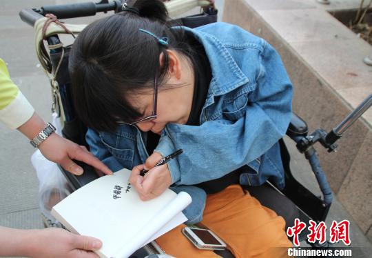 洛洛正在給買書的顧客簽名。 馮曉林 攝
