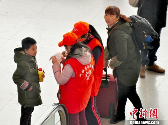 鐵路青年志愿者為攜帶兒童出行的旅客提供咨詢解答?！钦鳌z