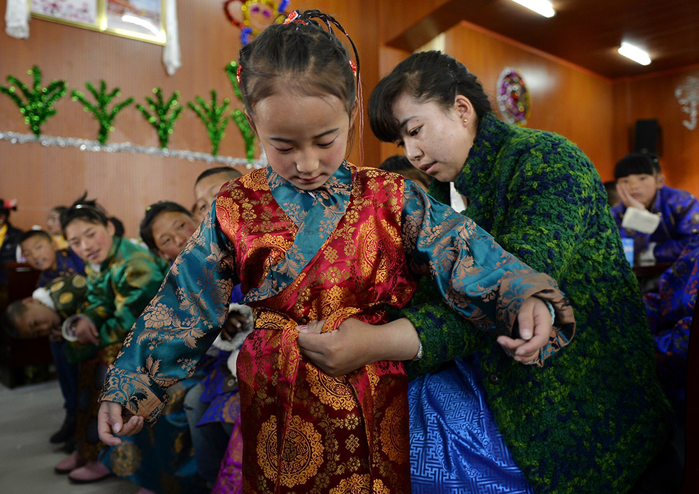 2月27日，在西藏自治區(qū)兒童福利院，來自拉薩市尼木縣的“愛心媽媽”德慶旺姆（右）在為來自那曲地區(qū)的嘎瑪曲宗換上節(jié)日盛裝。